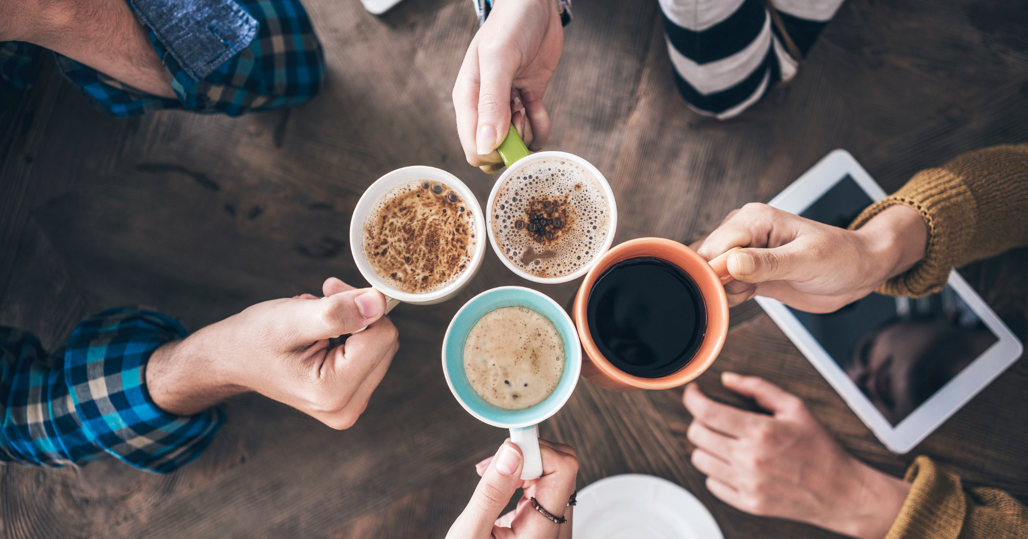 a group of people sitting around a table with cups of coffee