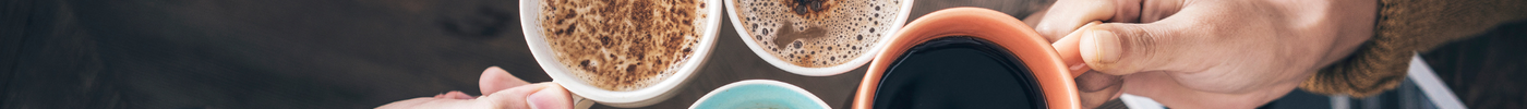 a group of people sitting around a table with cups of coffee