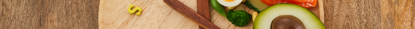 a wooden plate that uses cutlery to look like a clock with food placed in a specific 'time frame'