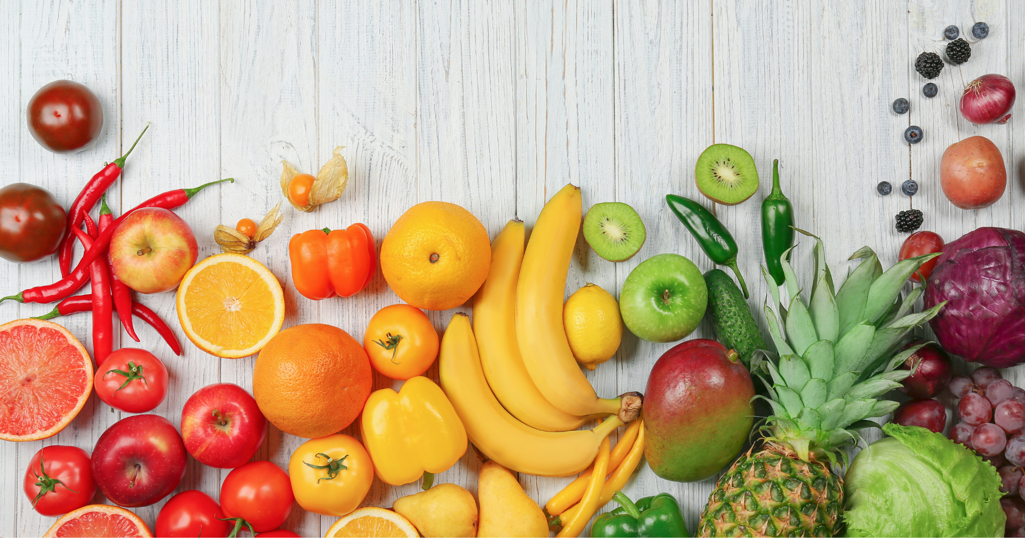 various fruits and vegetables arranged on a wooden table